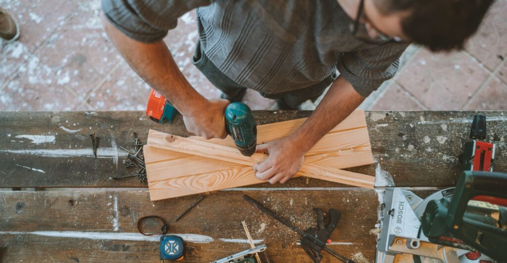 person uses drill on wood